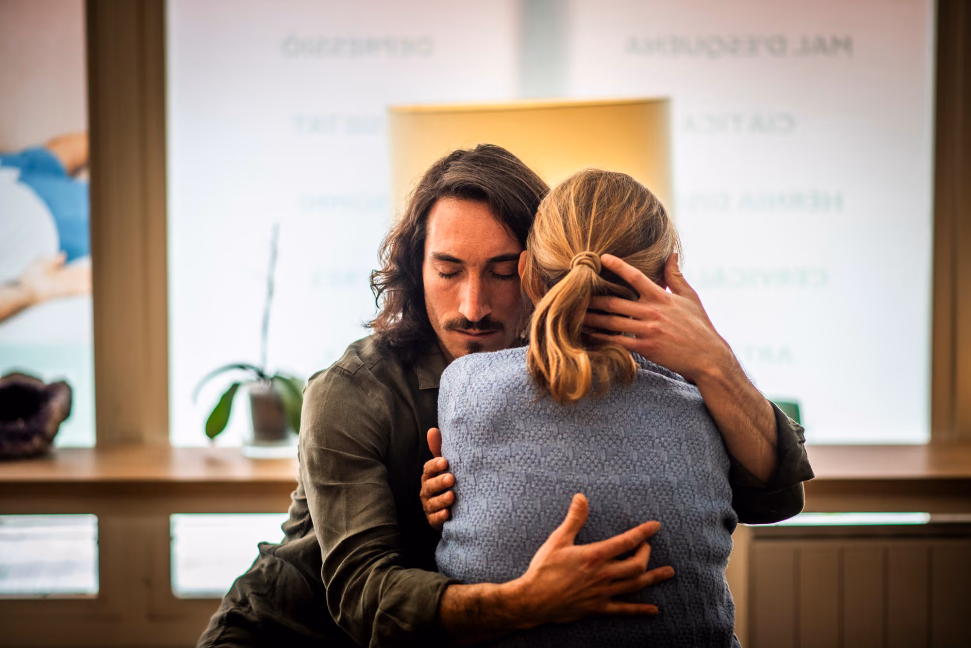 Miguel Vera abraza con los ojos cerrados a una mujer en la consulta.